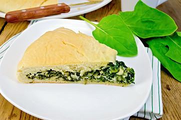 Image showing Pie with spinach and cheese on the board with leaves