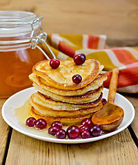 Image showing Flapjacks with cranberry and a jar of honey on the board