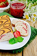 Image showing Roulade with strawberries and daisies on a board