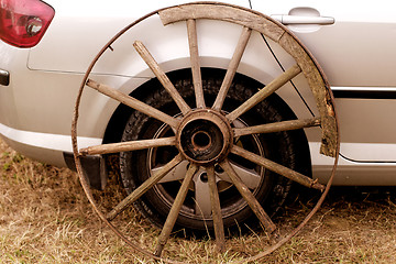 Image showing old wagon wheel addition on new cars