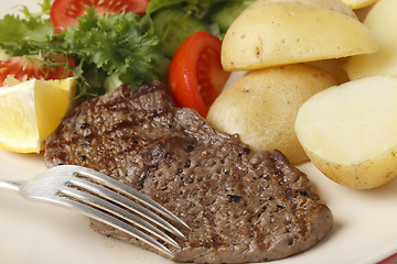 Image showing Minute steak meal closeup with fork