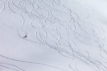 Image showing Snowboarder downhill on off piste slope with newly-fallen snow