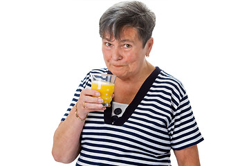 Image showing Elderly woman drinking orange juice