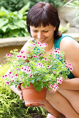 Image showing happy smiling middle age woman gardening