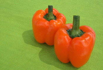 Image showing Orange peppers on green background