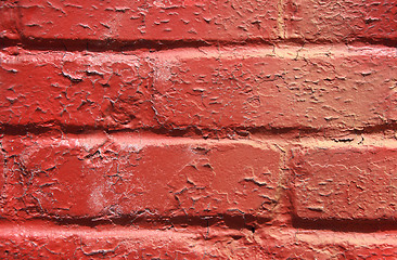 Image showing Red peeling paint on a brick wall