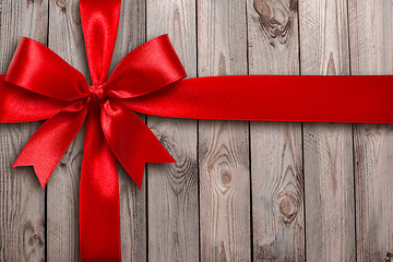 Image showing Red ribbon on a wooden background