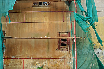 Image showing abandoned building with torn debris netting