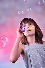 Image showing holiday portrait of happy child blowing soap bubbles