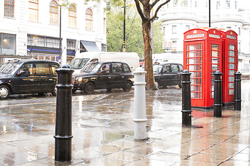 Image showing Red Phone cabines in London and vintage taxi.Rainy day.