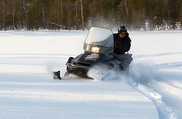 Image showing man riding a snowmobile