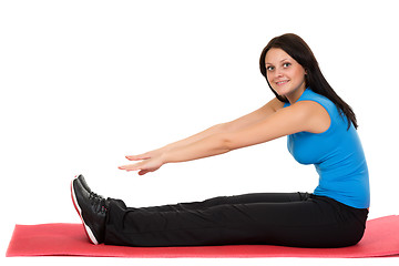 Image showing Young beautiful girl sitting on a yoga mat