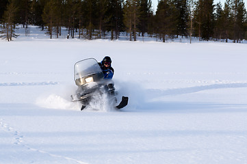 Image showing man riding a snowmobile