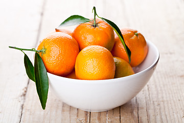 Image showing tangerines with leaves in bowl