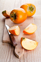 Image showing ripe persimmons and knife 