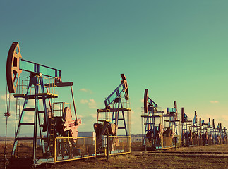 Image showing many working oil pumps in row - vintage retro style