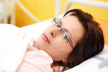 Image showing sad middle-aged woman lying in hospital