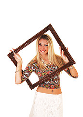 Image showing Girl looking trough picture frame.