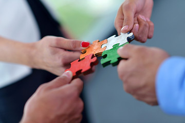 Image showing Group of business people assembling jigsaw puzzle