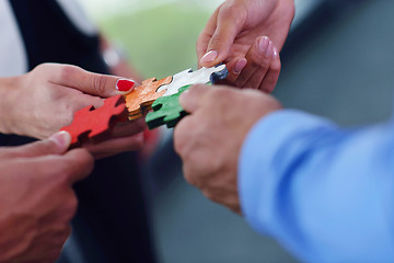 Image showing Group of business people assembling jigsaw puzzle