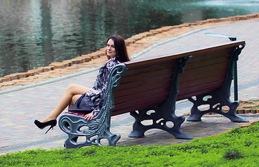 Image showing Woman sitting near the lake