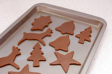 Image showing Cookie sheet with uncooked festive gingerbread biscuits