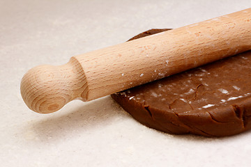 Image showing Closeup of rolling pin on gingerbread biscuit dough