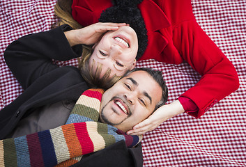 Image showing Mixed Race Couple Wearing Winter Clothing on Blanket in Park