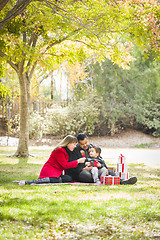 Image showing Mixed Race Family Enjoying Christmas Gifts in the Park Together