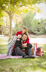 Image showing Mixed Race Family Enjoying Christmas Gifts in the Park Together