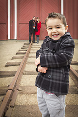 Image showing Mixed Race Boy at Train Depot with Parents Smiling Behind