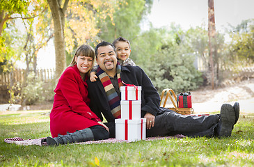 Image showing Mixed Race Family Enjoying Christmas Gifts in the Park Together