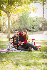 Image showing Mixed Race Family Enjoying Christmas Gifts in the Park Together