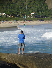 Image showing Fishing on top of the rock at the beach