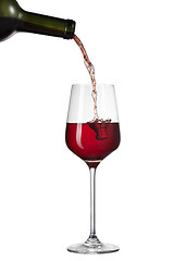 Image showing Red wine pouring into glass with splash isolated on white