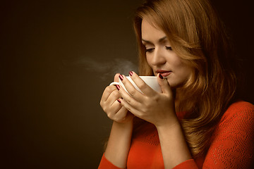 Image showing woman holding hot cup and smiles