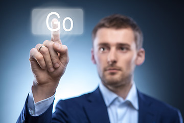 Image showing business man pressing Go button on touchscreen