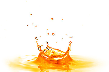 Image showing drop falling into orange water with splash isolated on white