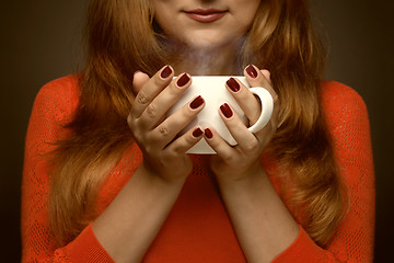 Image showing woman holding hot cup and smiles