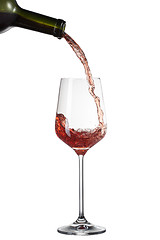 Image showing Red wine pouring into glass with splash isolated on white