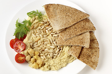 Image showing Lebanese hummus and pine nuts from above