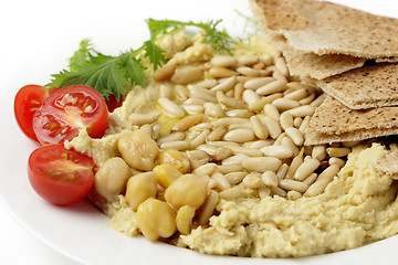 Image showing Lebanese hummus and pine nuts withoil