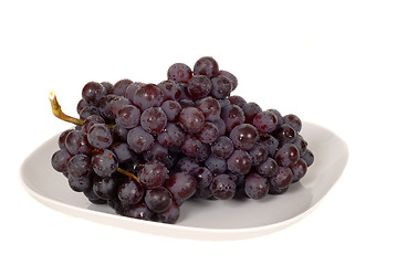 Image showing A bunch of juicy red grapes on a white plate