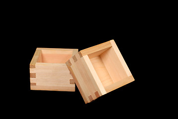 Image showing Two wooden sake cups on a black background