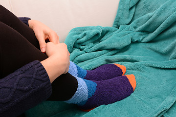 Image showing Woman hugging her legs, wearing warm socks