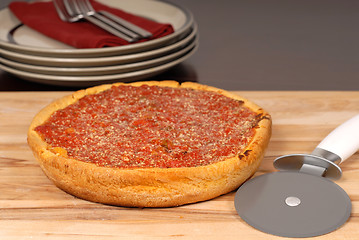 Image showing A Chicago style deep dish pizza on a cutting board