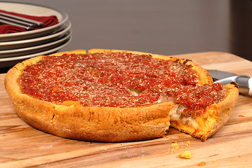 Image showing Chicago style deep dish pizza with a piece cut out