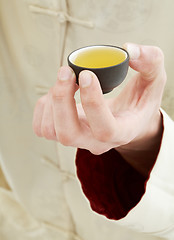 Image showing hand holding cup of green tea