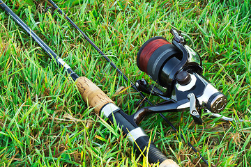 Image showing Spinning fishing on the green grass by the river.