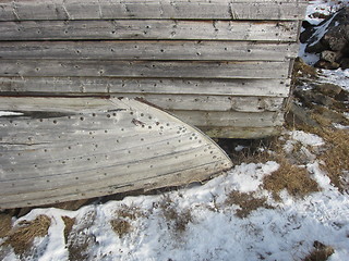 Image showing Old wooden boat by an wooden house